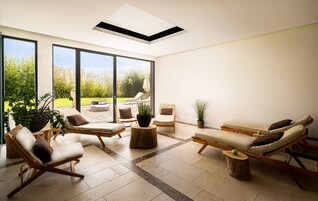 Una sala de estar moderna con ventanas amplias, una lámpara de techo y vistas al exterior.