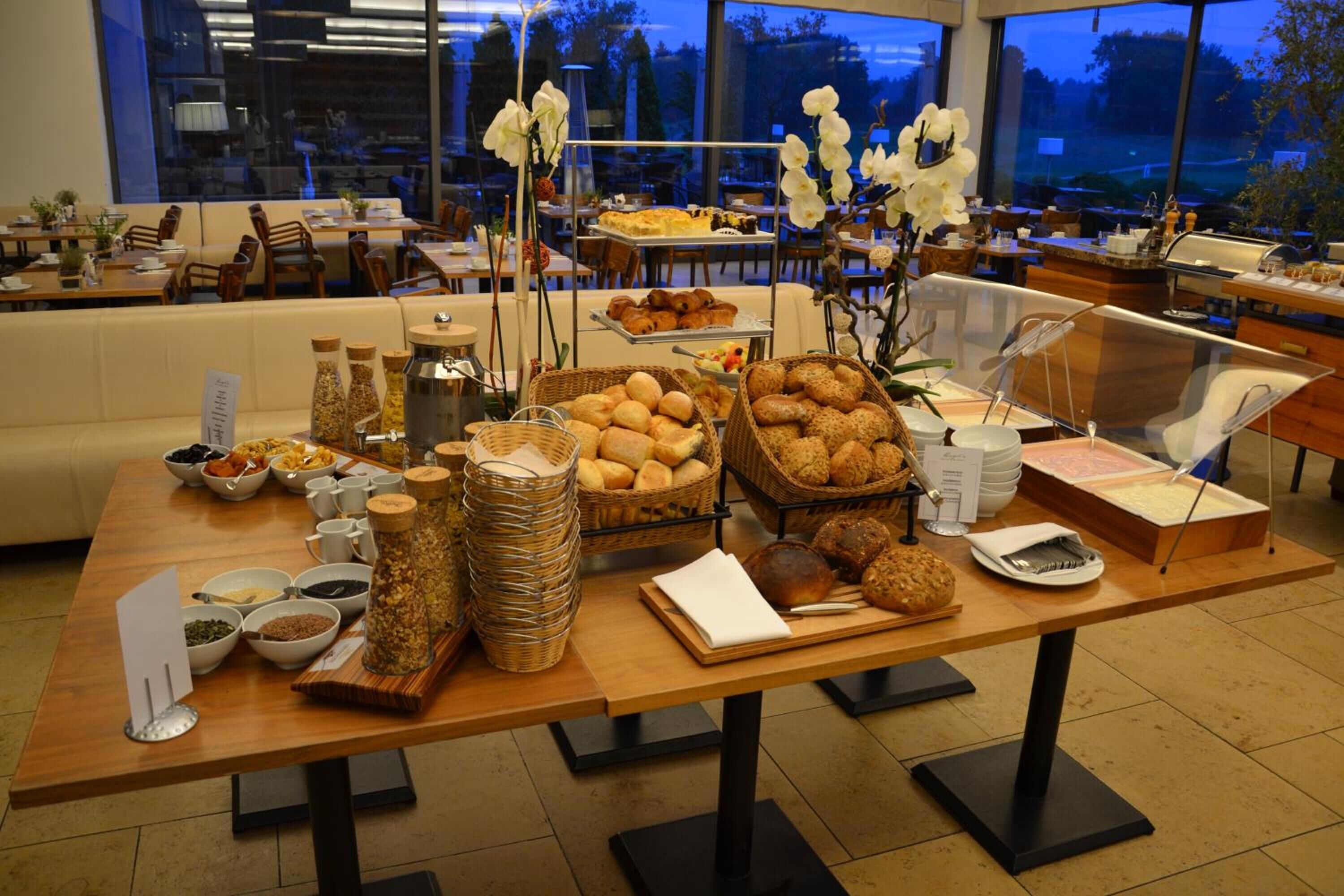 Mesa de buffet con diferentes alimentos y un área de estar al fondo.