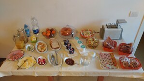 A table with various food items and condiments, including sliced meats, cheeses, and bread. - B&B Principe Calaf 4 (Lucca)