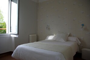 Une chambre à coucher avec un lit, une fenêtre et un radiateur.