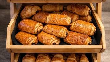 Una teca in legno con tre file di pasticceria.