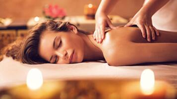 Eine Person liegt auf einer Massageliege und erhält eine Rückenmassage.