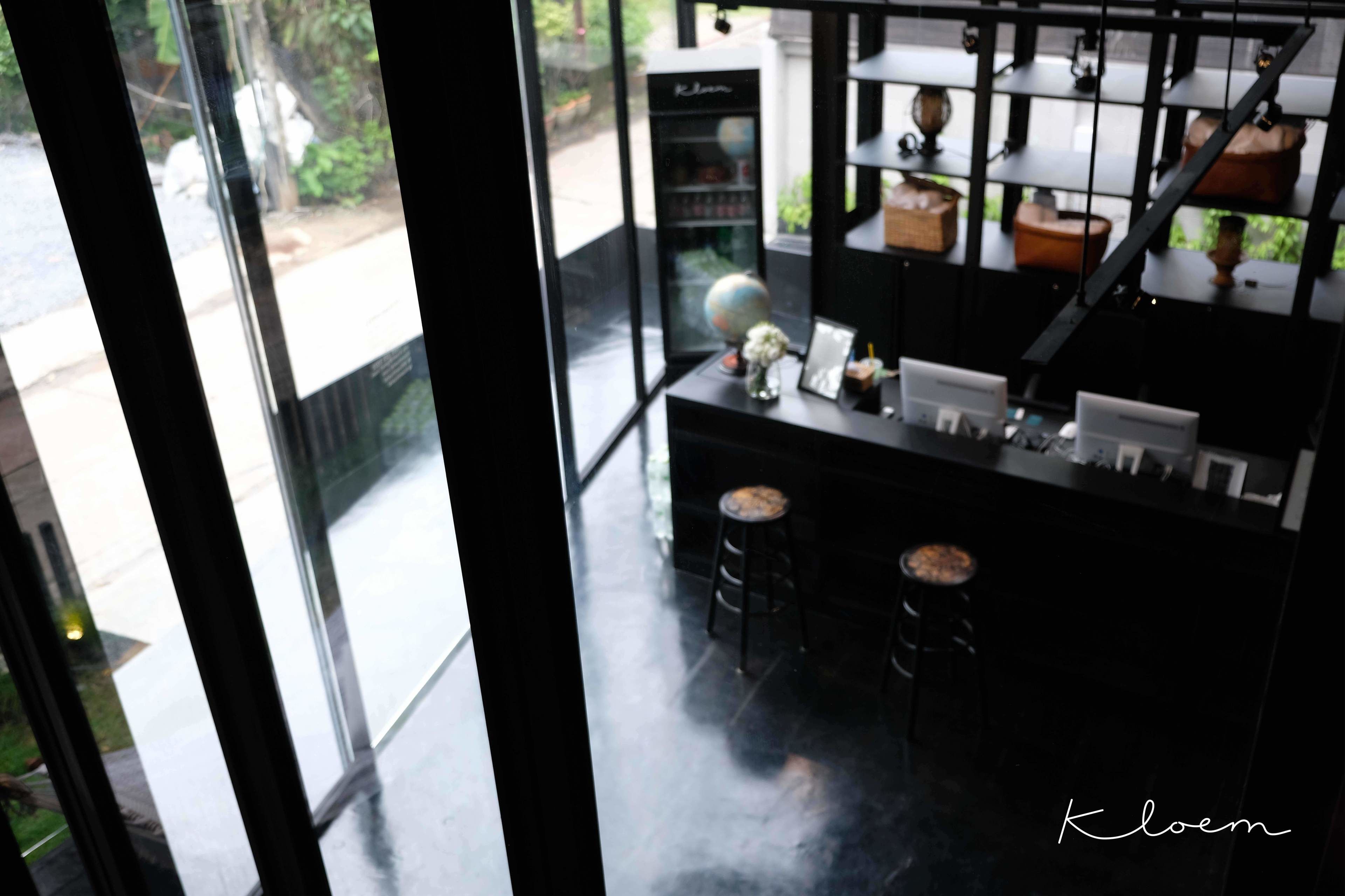 A modern interior with a black counter, two stools, a globe, and a shelf with decorative items.