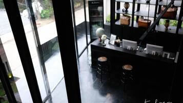 A modern interior with a black counter, two stools, a globe, and a shelf with decorative items.