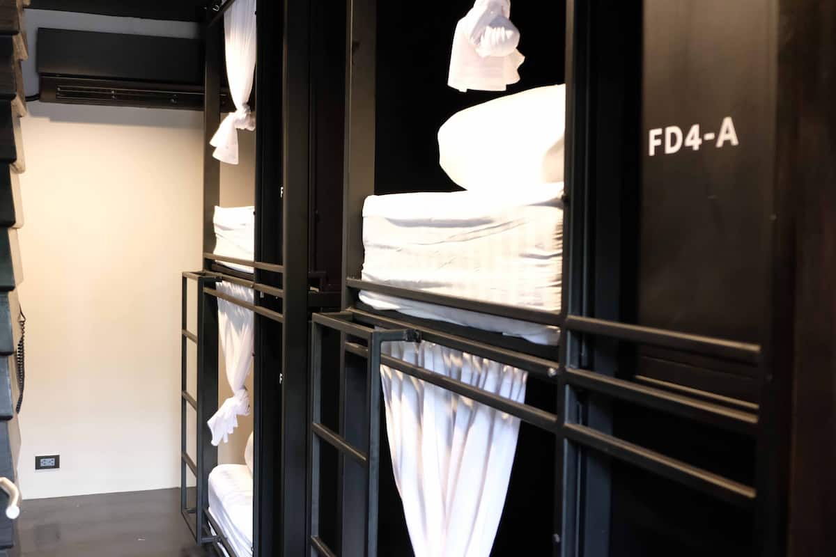 A hotel room with a bed, curtains, and a sign reading "FD4-A".
