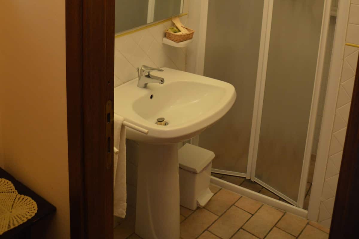 Un baño con lavamanos, espejo y ducha.