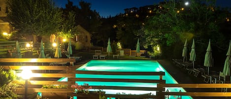 Una piscina al aire libre de temporada, sillones reclinables de piscina