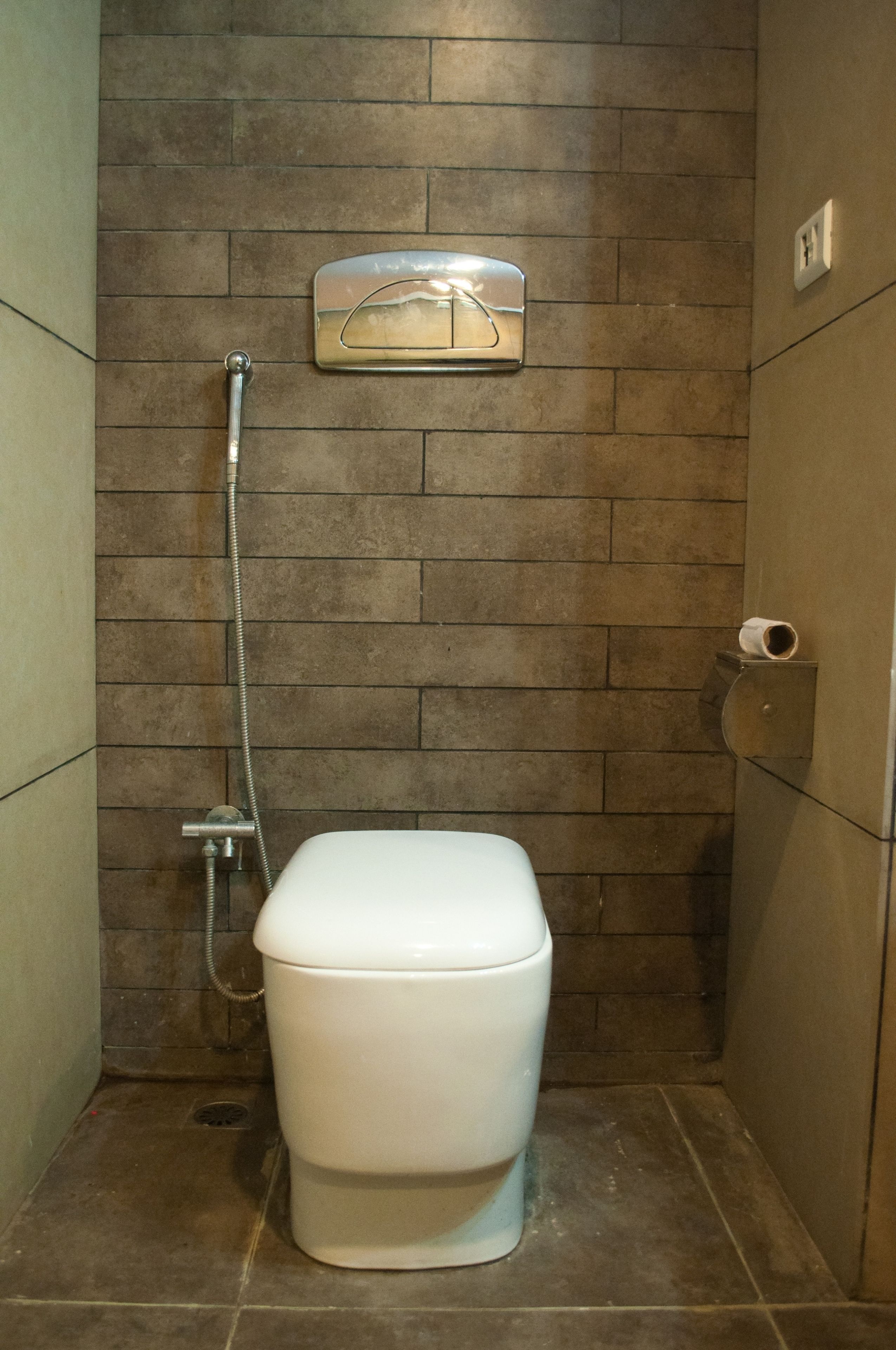 A bathroom with a toilet, a shower, and a towel rack.
