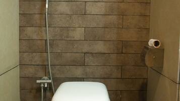 Ein Badezimmer mit Toilette, Dusche und Handtuchhalter.