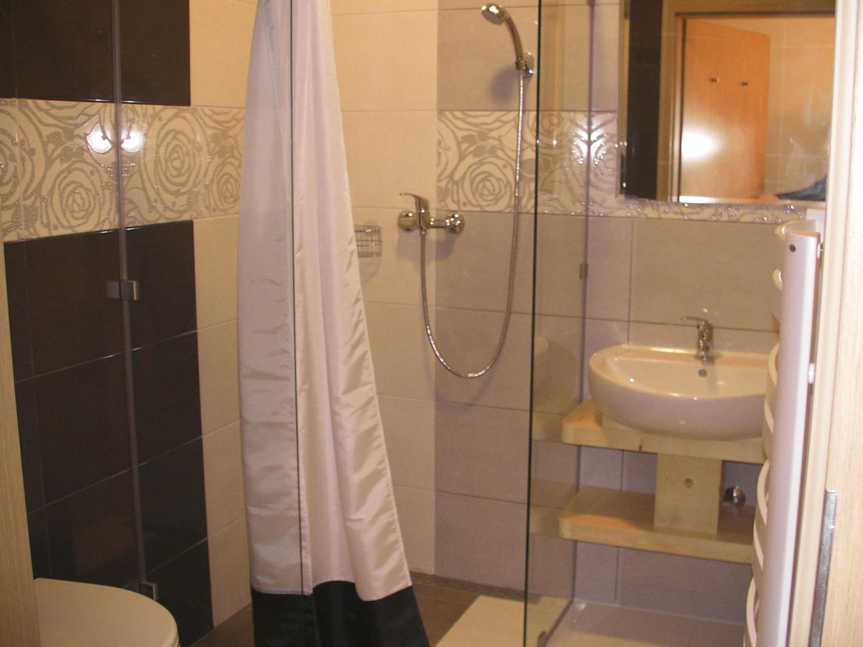 A bathroom with a shower, toilet, and sink.