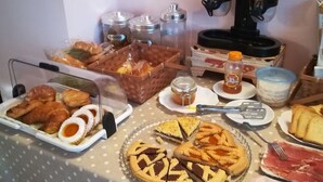 A buffet table with various food items including pastries, sandwiches, and a pie. - La Stregatta B&B (Fucecchio)
