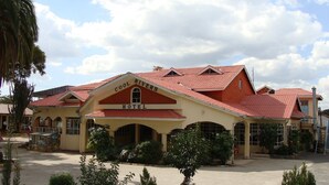 A hotel with a red-tiled roof and a sign that reads "Cool Rivers Hotel." - Cool Rivers Hotel (Nakuru)