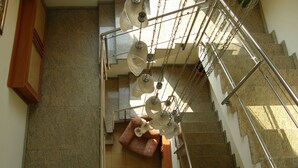 Una escalera con barandilla de metal y protección de vidrio en la parte inferior.