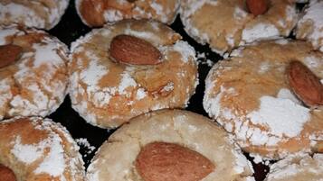 Un vassoio con biscotti rotondi, mandorle e zucchero a velo.