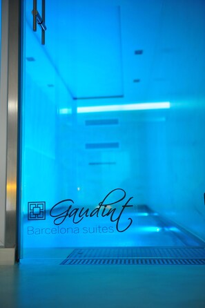 A blue-lit corridor with a sign reading "Gaudint Barcelona suites." - Gaudint Barcelona suites (Barcelona)