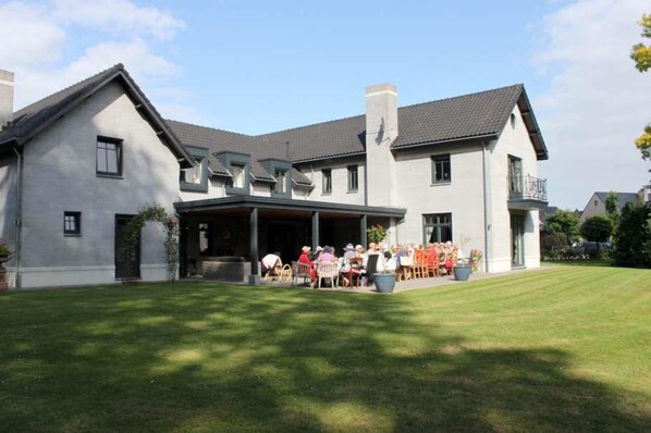 A large, modern building with a covered patio area. - Bed and Breakfast Mooi Achel (Hamont-Achel)