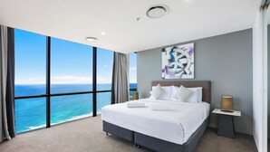 A modern hotel room with a large bed, a bedside table, a nightstand, a large window with a view of the ocean, and a ceiling light. - One and Only - Circle on Cavill Sub Penthouse 2672 - 5 bedrooms Level 67 (Gold Coast)