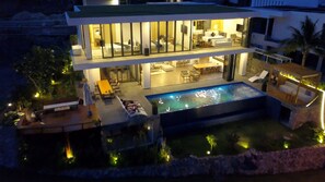 Vista frontal de la propiedad por la tarde o noche