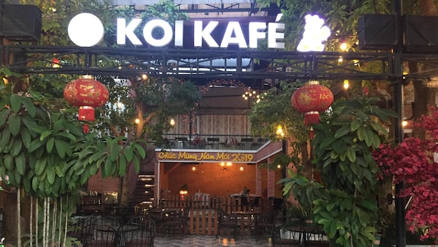 Entrada a un restaurante con un letrero que dice "KOI KAFE".