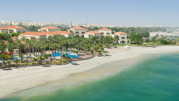 A resort with multiple buildings, a sandy beach, and a pool area. - Al Raha Beach Hotel Villas (Abu Dhabi)