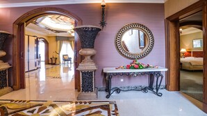 A lobby with a marble floor, a large mirror, a decorative vase, and a table with flowers. - Al Raha Beach Hotel Villas (Abu Dhabi)