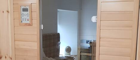 Una sauna con panel de control, un banco y sistema de ventilación.