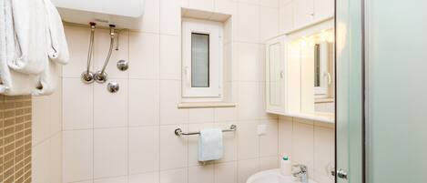 A bathroom with a toilet, sink, and shower.