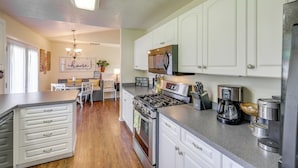 A modern kitchen with white cabinetry, a gas stove, a coffee maker, and a microwave. - Bitterroot Mountain Views: Montana Family Home! (Hamilton)