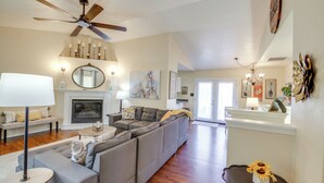 A spacious living room with a fireplace, a ceiling fan, and a dining area with a table and chairs. - Bitterroot Mountain Views: Montana Family Home! (Hamilton)