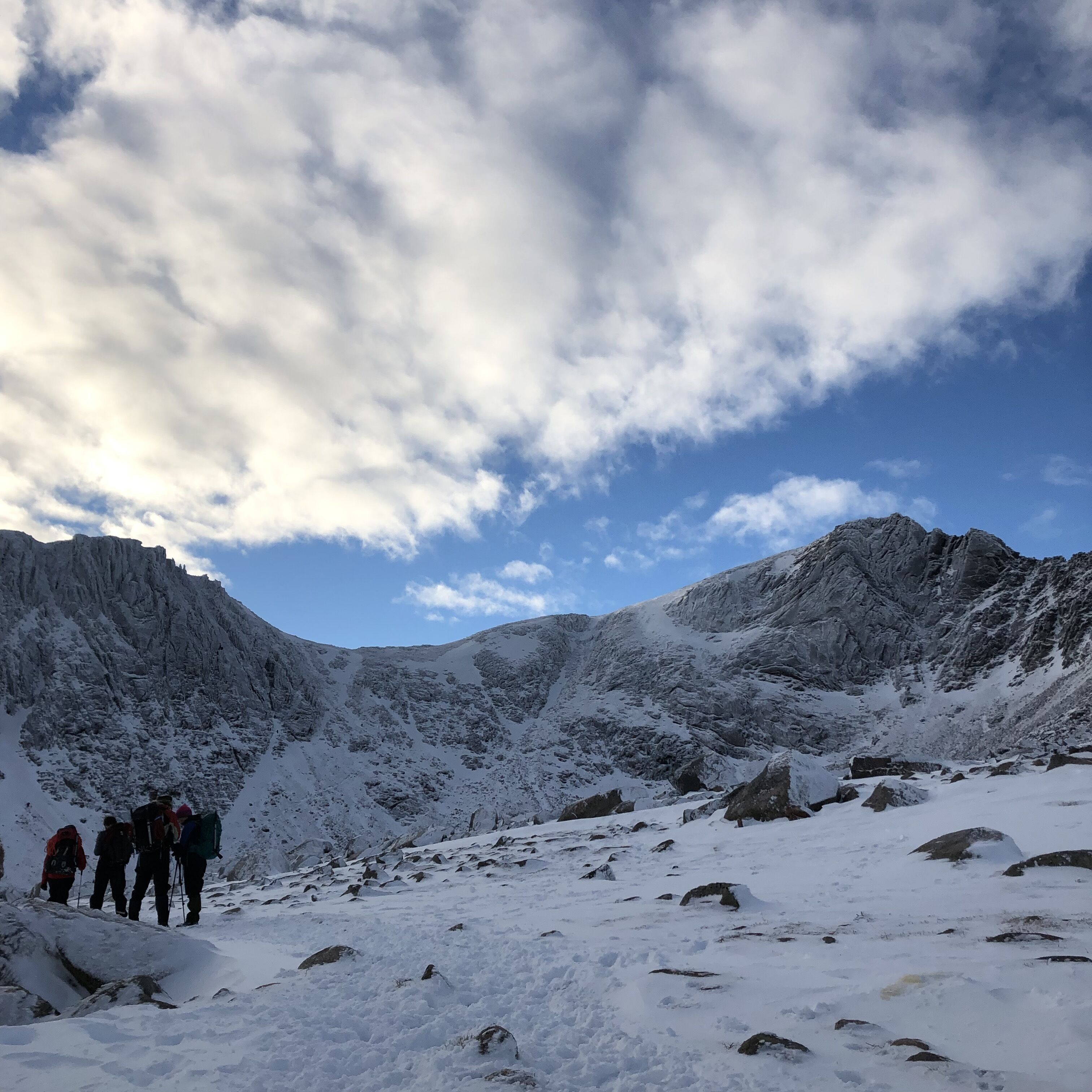 A snowy mountain landscape with rocky terrain and a clear sky.