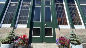 Un edificio con una puerta verde que dice "Ravenscraig" y un cielo azul despejado.
