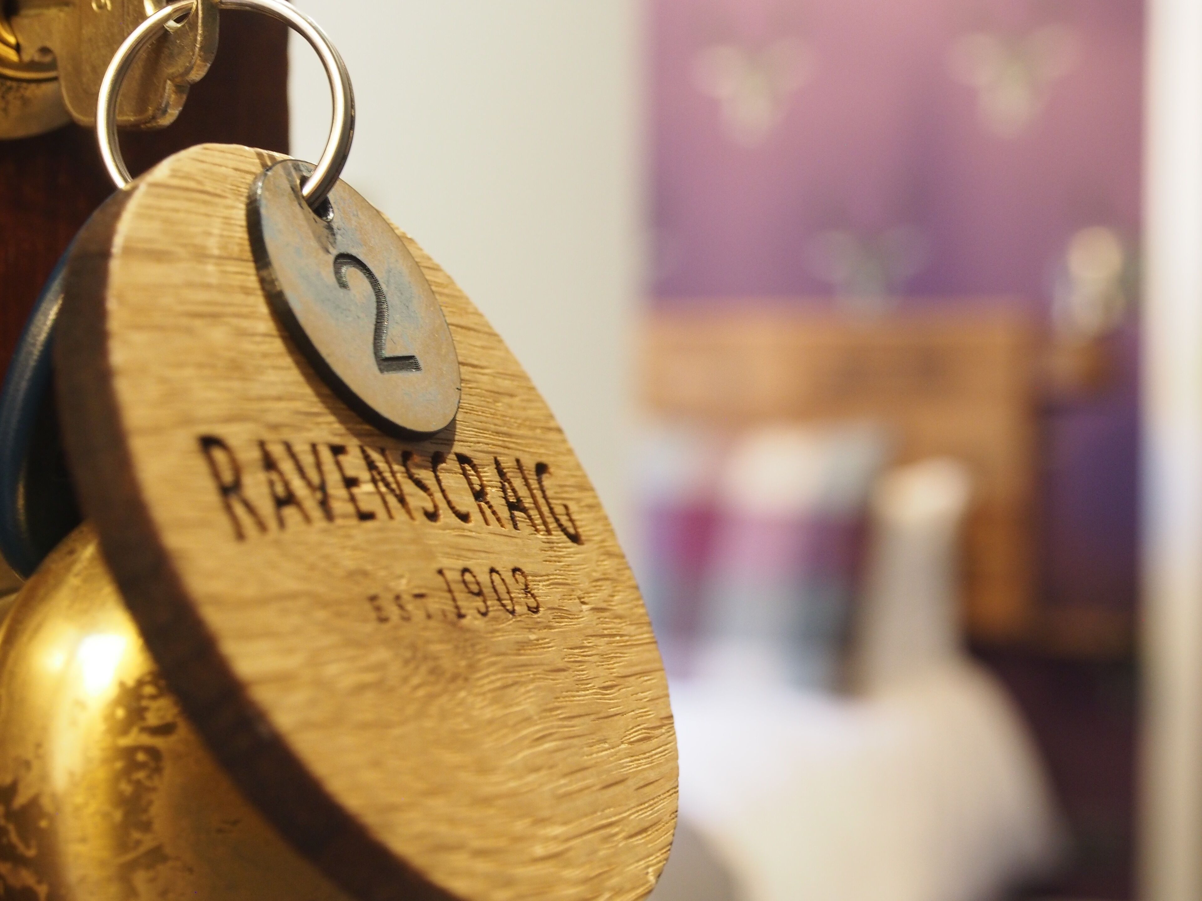 A wooden keychain with the inscription "RAVENSCRAG EST. 1903".