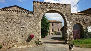 A stone archway leading to a building with a tiled roof. - Logis De Riparfonds (Bressuire)