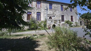 A stone building with multiple windows and a central archway. - Logis De Riparfonds (Bressuire)