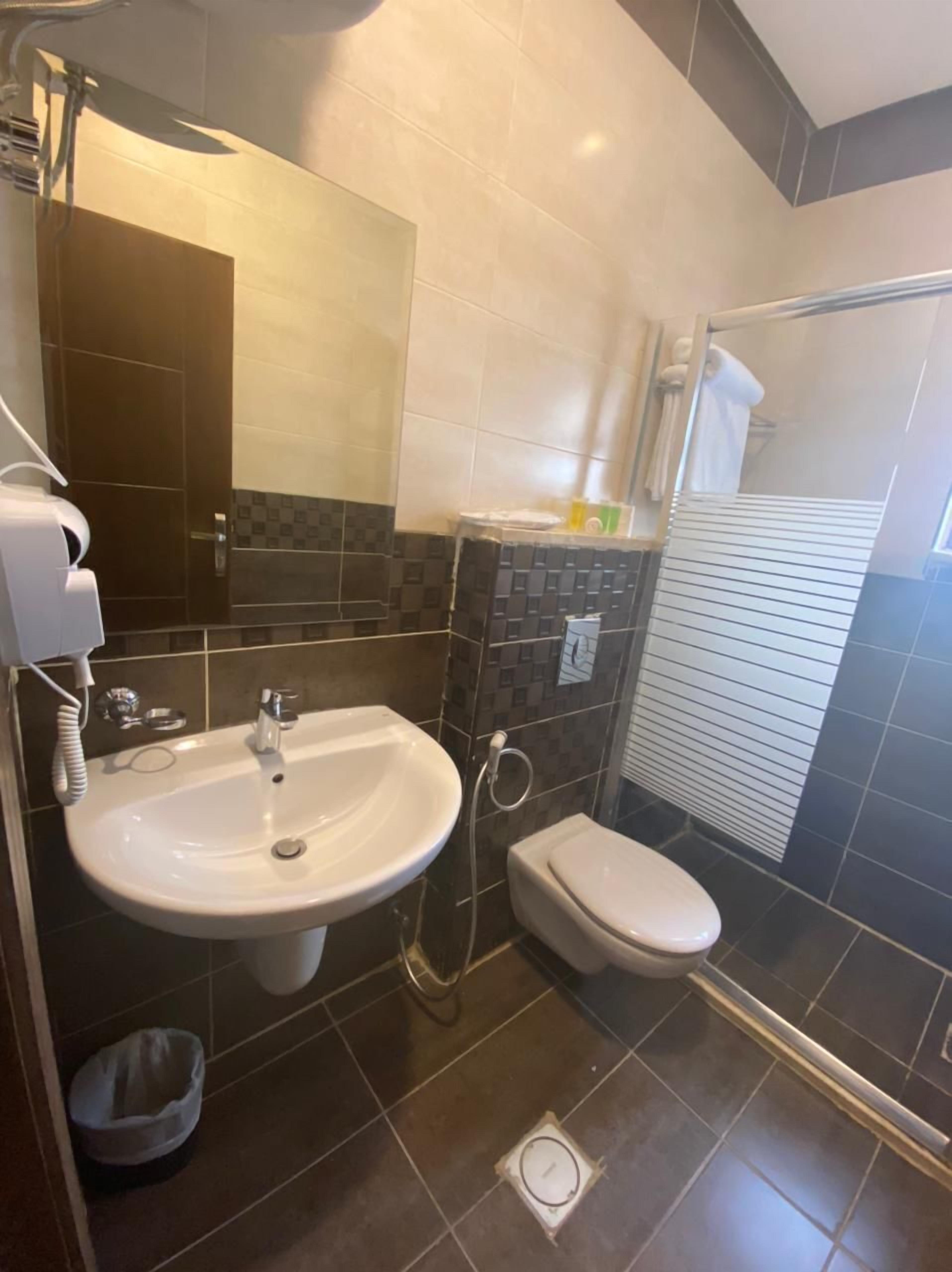 Une salle de bain moderne équipée d’un lavabo, de toilettes et d’une douche.