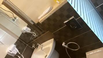 A bathroom with a sink, mirror, and towel rack. The walls are tiled in a checkered pattern of dark and light tiles.