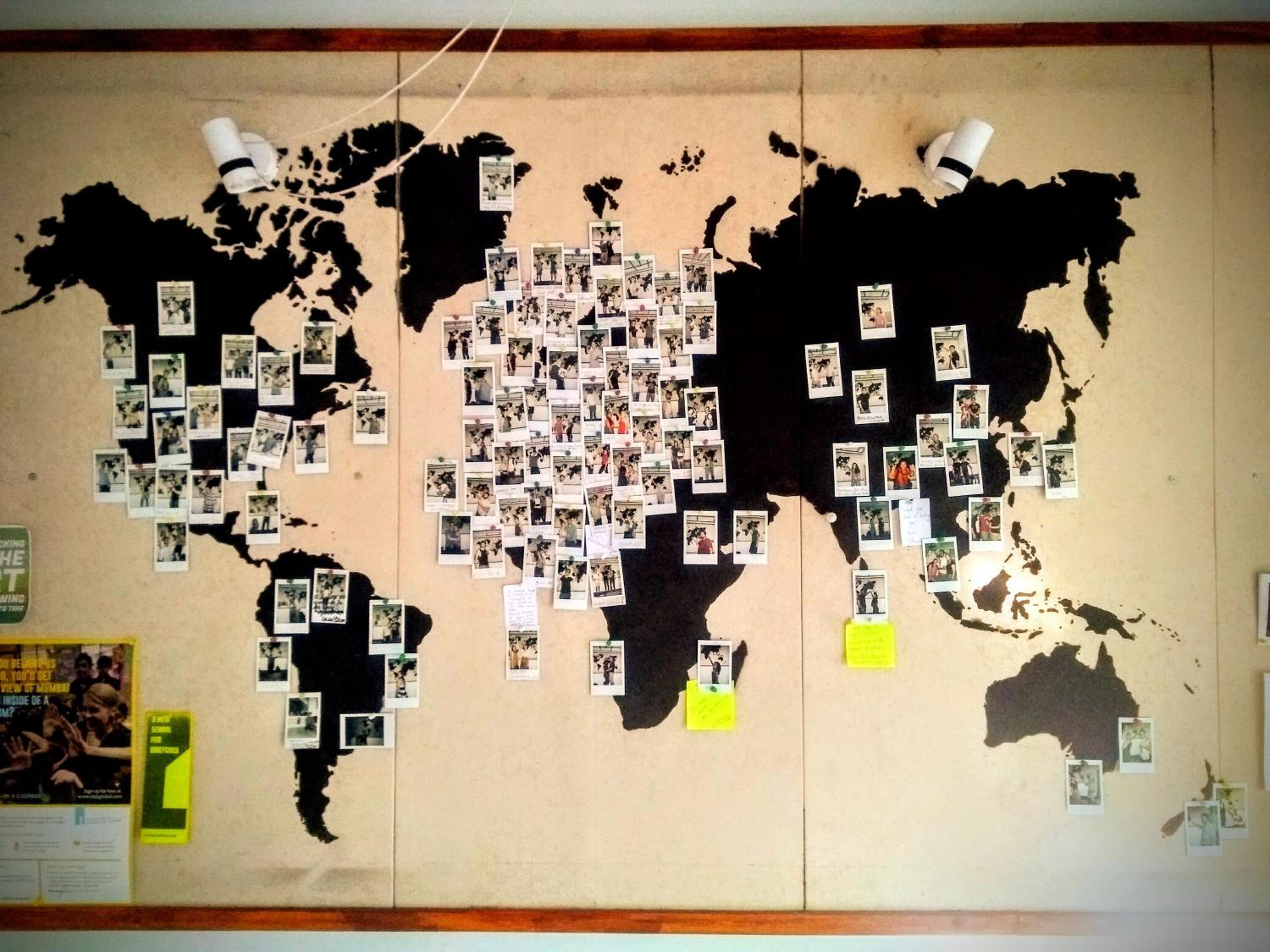 A world map with photos pinned to various locations.
