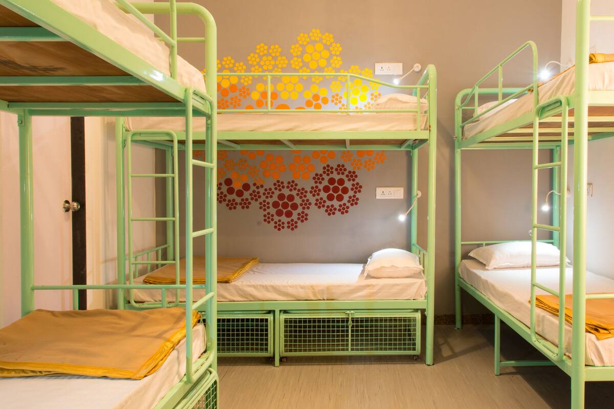 Ein Schlafsaalzimmer mit Etagenbetten, einer Chandelieber und einer Wanddekoration.