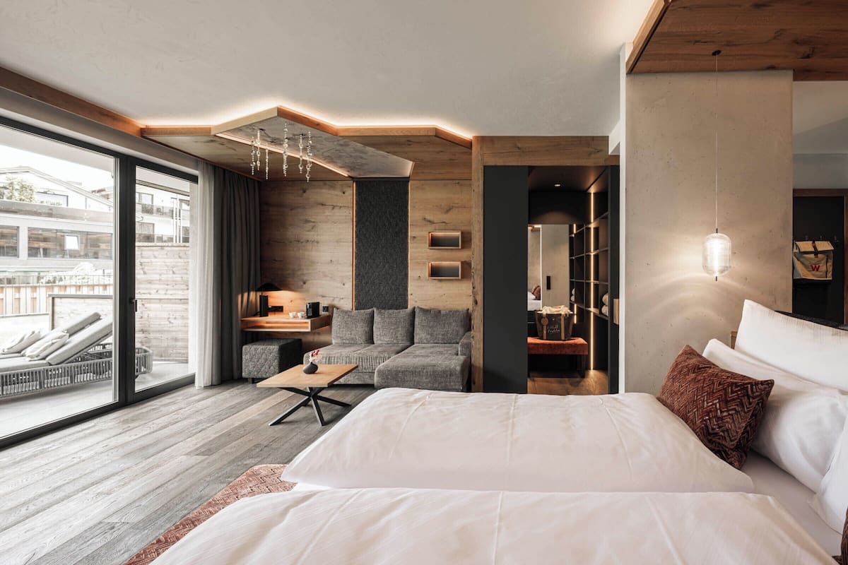 Une chambre d’hôtel moderne, dotée d’un grand lit, d’un canapé, d’un bureau et offrant une vue sur l’extérieur.