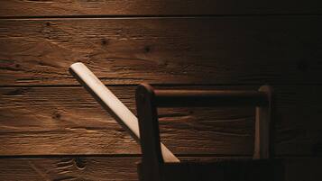 A wooden wall with a chair and a white object leaning against it.