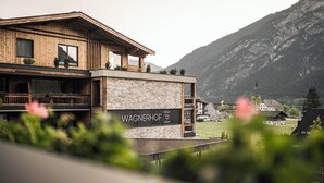 Un edificio moderno con fachada de madera y pared de piedra, identificado como "WAGNERHOF".