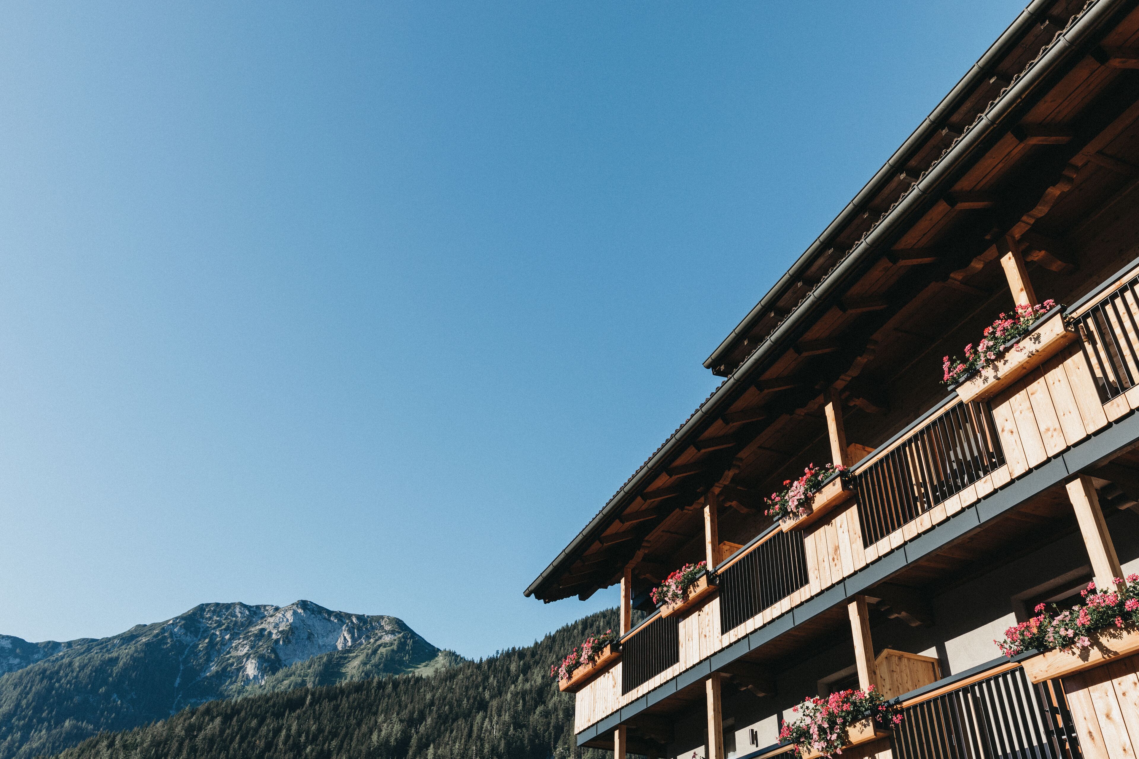 A wooden building with balconies, each with flower boxes.