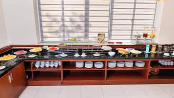 A buffet setup with various food items and a coffee station.