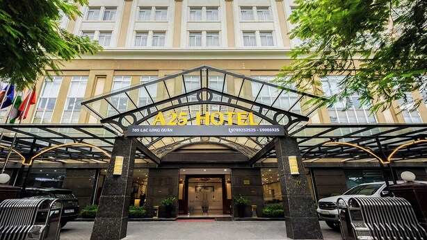 L’entrée d’un hôtel, avec une grande enseigne, un porche et un espace de stationnement pour les voitures.