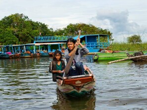 A boat with two passengers on a calm river. - Siem Reap Homesteading (Siem Reap)