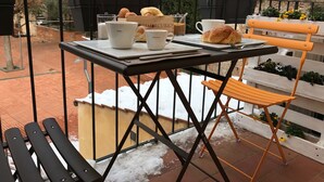 A balcony with a table set for breakfast, including croissants, coffee cups, and a sign reading "TEMERCURIO". - Fonte Gaia Experience B&B (Siena)