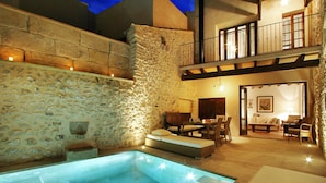 A stone-walled outdoor area with a pool, a dining table, and a sofa. - Mallorca One by Balearic Villas (Pollensa)