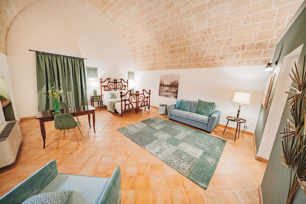 A spacious living room with a high ceiling, a dining area, and a sofa.