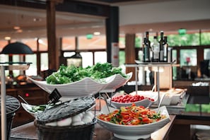 A buffet with various dishes, including salads and a selection of beverages.
