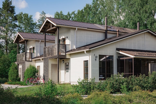 A two-story house with a balcony, large windows, and a garage.